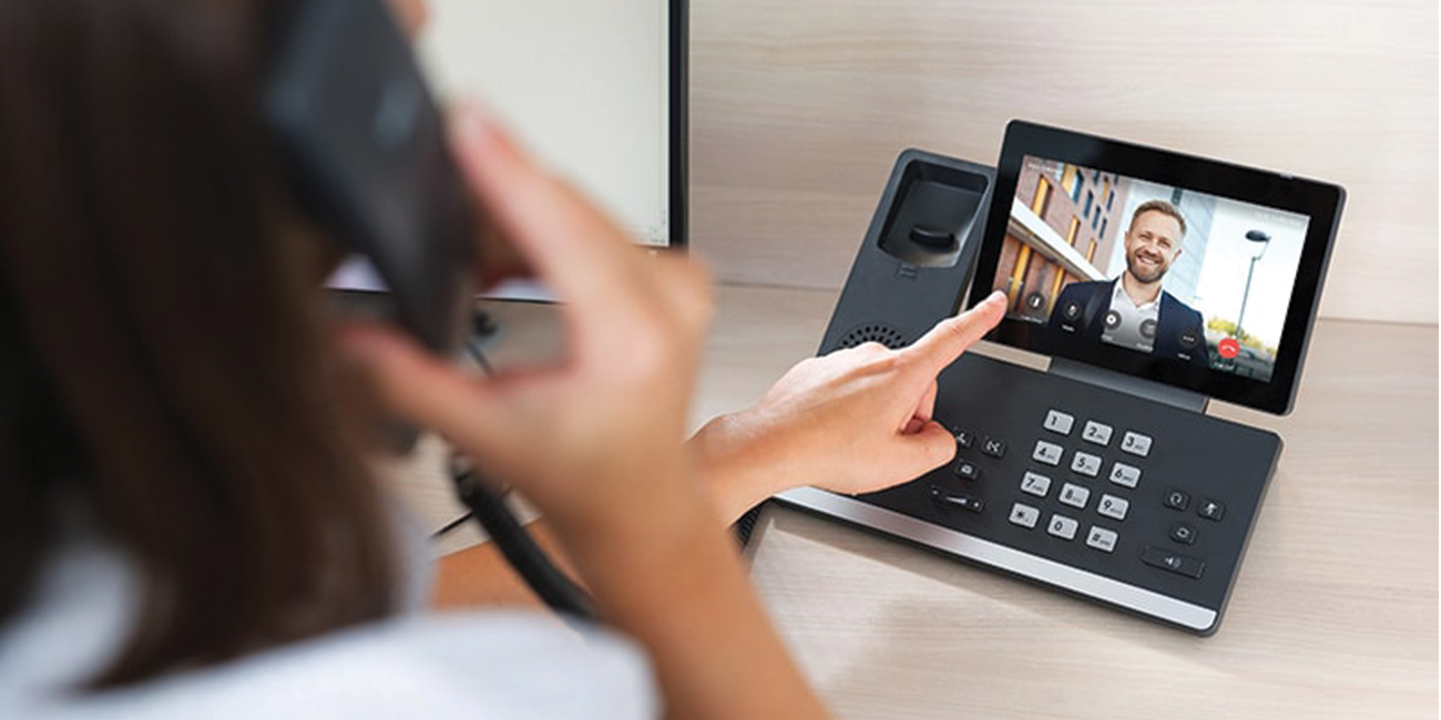 A Teams certified desk phone alongside Microsoft Teams