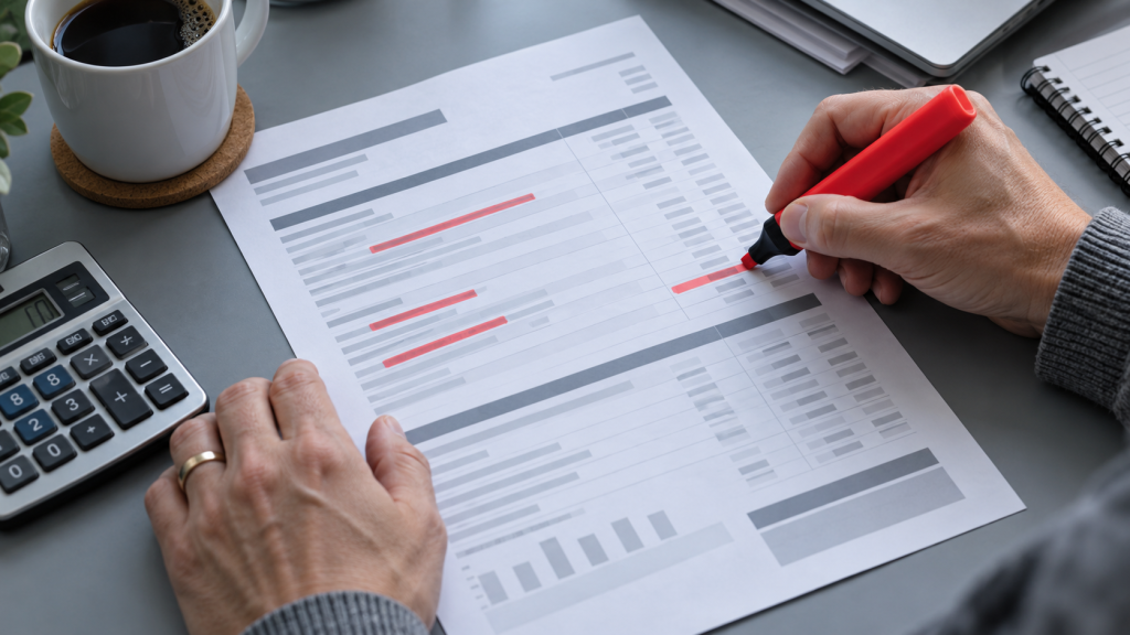 Marking up a printed business mobile bill with a highlighter